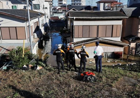 Rescue workers from the Kawasaki City Fire Department look at a flooded residential area due to Typhoon Hagibis, near the Tama River in Kawasaki