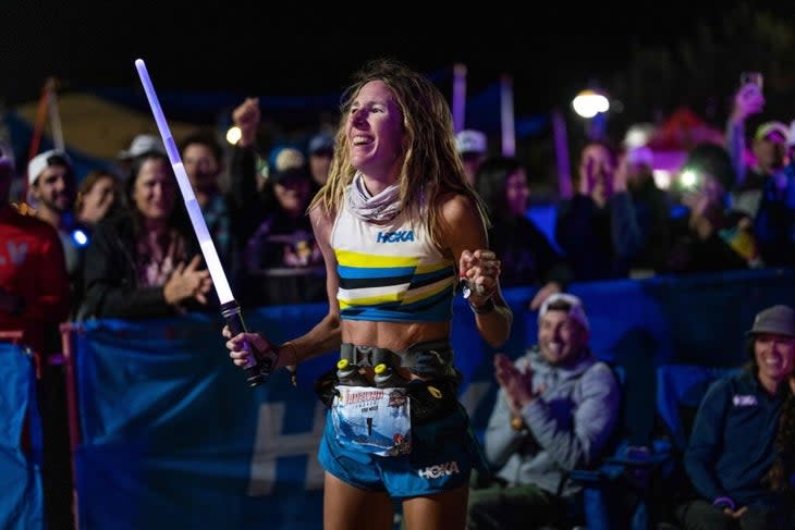 woman finisher of the race with a laser sword in her hand
