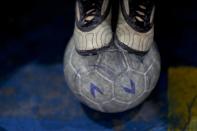 En esta foto del 11 de noviembre de 2016, un joven jugador se detiene sobre un balón de futbol durante un juego de entrenamiento en la academia de futbol juvenil Club Social Parque, en un vecindario de clase trabajadora en Buenos Aires, Argentina. Club Social Parque se fundó en 1949 y ahora tiene unos 150 niños de todos los niveles socioeconómicos que entrenan juntos dos veces por semana y compiten en fines de semana en pequeñas canchas cubiertas. (AP Foto/Natacha Pisarenko)