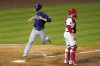 Tampa Bay Rays' Joey Wendle, left, scores on a double by Kevin Kiermaier as Los Angeles Angels catcher Max Stassi stands at the plate during the sixth inning of a baseball game Tuesday, May 4, 2021, in Anaheim, Calif. (AP Photo/Mark J. Terrill)