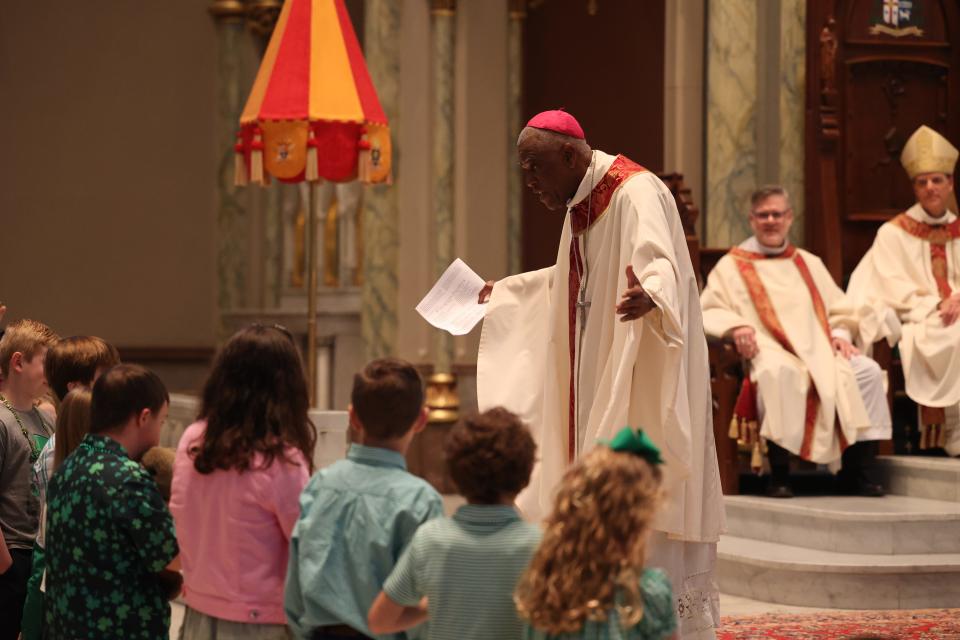 Most Rev. Jaques Fabre-Jeune gives the homily to a group of children during the St. Patrick's Day Mass on Saturday, March 16, 2024.