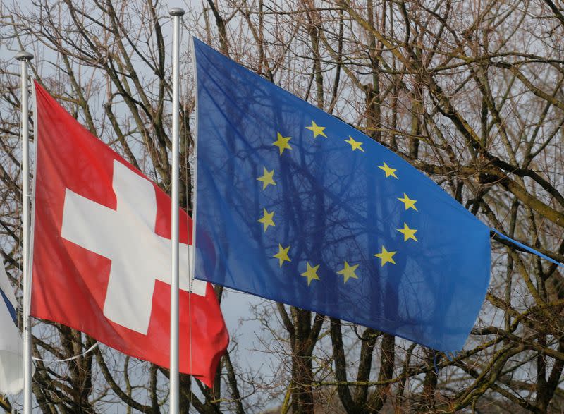 FILE PHOTO: Switzerland's national flag flies beside the one of the European Union in Steinhausen