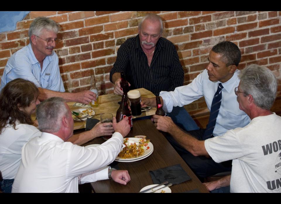 Obama clinks beer glasses with unemployed construction workers as they sit down for a discussion at the Harp and Celt Restaurant and Irish Pub in Orlando, Florida, October 11, 2011. AFP PHOTO / Saul LOEB 