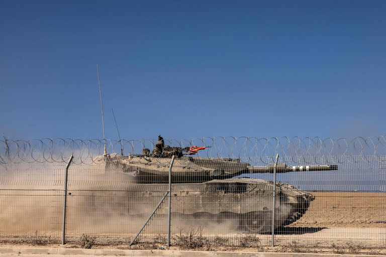 Un tanque Merkava israelí pasa junto a una valla cerca del Kibbutz Beeri, cerca de la frontera con Gaza