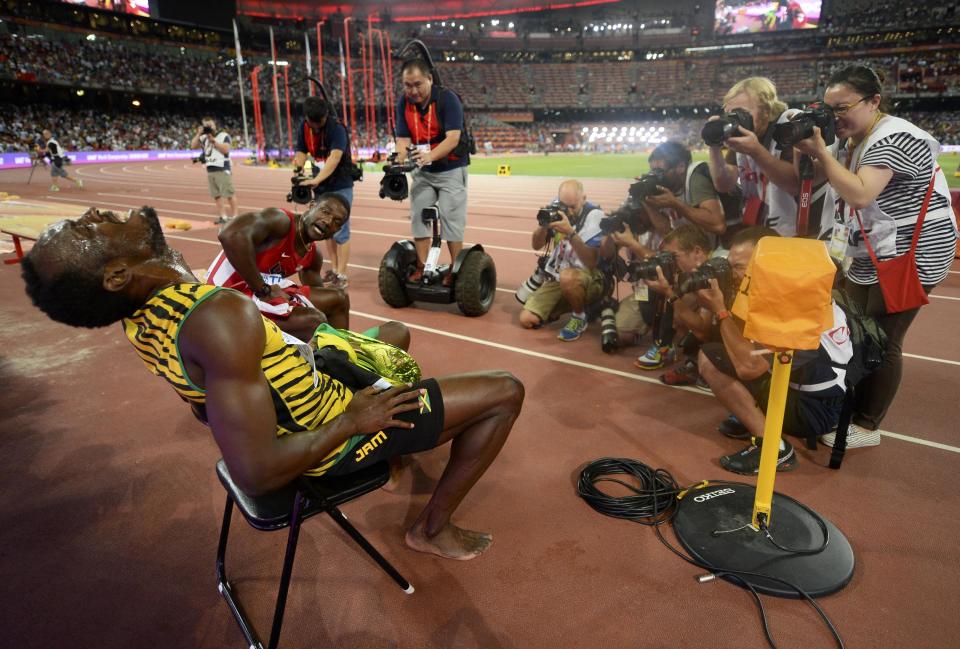 Usain Bolt of Jamaica (L) poses for photographers after winning the men's 200 metres final as Justin Gatlin from the U.S. looks on during the 15th IAAF World Championships at the National Stadium in Beijing, China, August 27, 2015. REUTERS/Dylan Martinez TPX IMAGES OF THE DAY