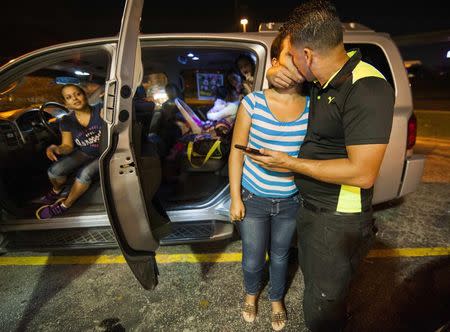 Cuban migrant Mailin Perez kisses with her husband Jose Caballero after arriving via Mexico at a bus station in Austin, Texas September 25, 2014. REUTERS/Ashley Landis