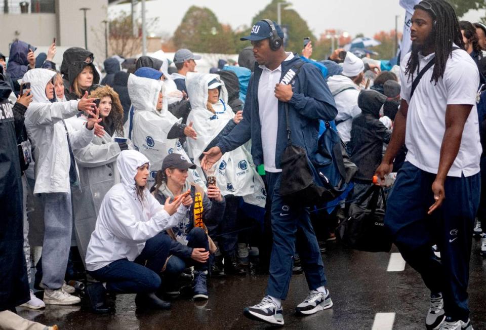 Penn State football players high-five fans as they arrive at Beaver Stadium for the game against UMass on Saturday, Oct. 14, 2023.  