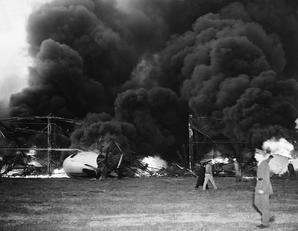 <p>Black smoke rises from the skeleton of the burning Hindenburg airship at Lakehurst, N.J., May 6, 1937. The German-built zeppelin caught fire and exploded mid-air as it was landing after its transatlantic voyage, carrying 97 passengers and crew. Thirty-five people on board and one ground crew member were killed. (AP Photo/Murray Becker) </p>