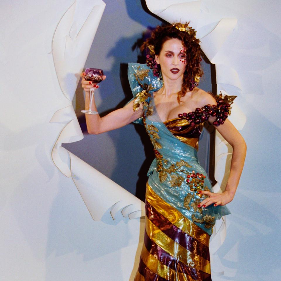 Woman posing in an elaborate gown with a sculptural design and textured layers