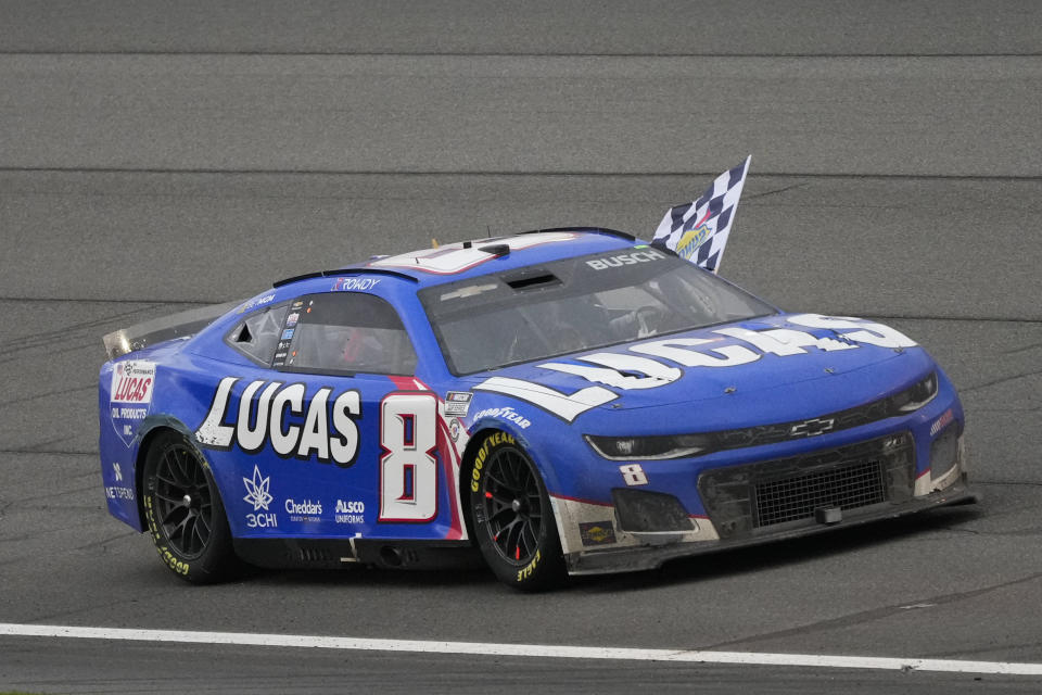 Kyle Busch waves a checkered flag while celebrating after winning the NASCAR Cup Series auto race at Auto Club Speedway in Fontana, Calif., Sunday, Feb. 26, 2023. (AP Photo/Jae C. Hong)