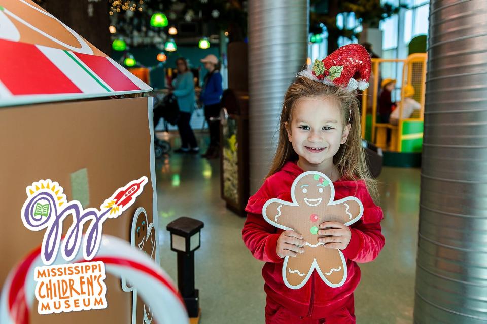 Scarlett Rose Weikleenget holds up a gingerbread man for the new Build a Gingerbread House at the Mississippi Children’s Museum.