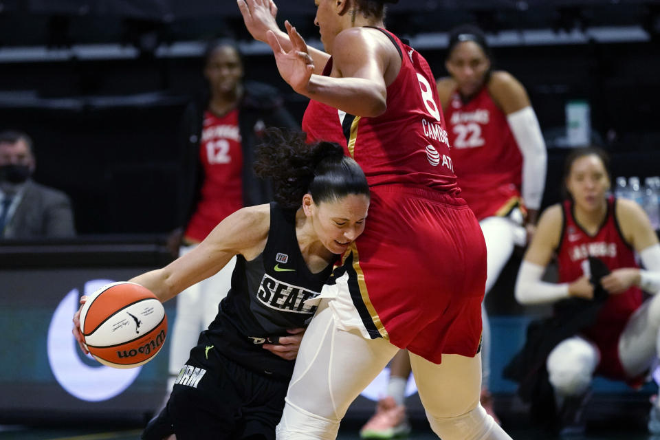 Seattle Storm's Sue Bird, left, runs into Las Vegas Aces' Liz Cambage in the second half of a WNBA basketball game Saturday, May 15, 2021, in Everett, Wash. Bird briefly left the game with an apparent injury on the play, but returned later in the game. The Storm won 97-83. (AP Photo/Elaine Thompson)