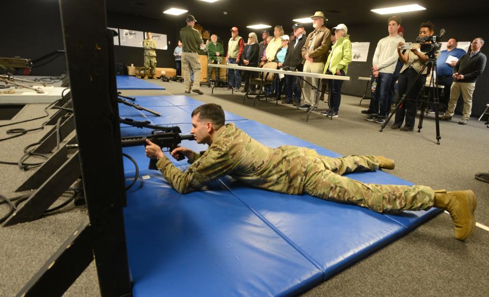 As part of a tour Friday for civilians of Camp Edwards at Joint Base Cape Cod in Bourne, Jonathan Marsh fires an M4 rifle as he demonstrates a virtual firing range where the weapons are powered by compressed air.