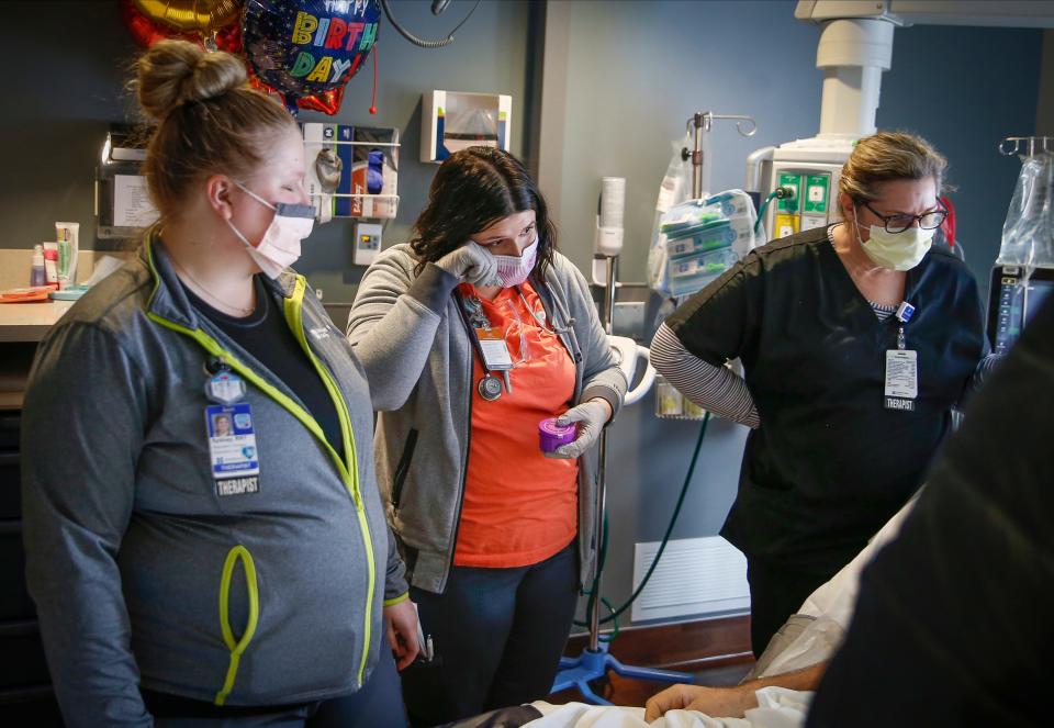 Mira Blum, center, a registered respiratory therapist in the Critical Care Unit at UnityPoint Methodist Medical Center in Des Moines, wipes away a tear on Jan. 6, 2022, when a COVID-19 patient said his first words after being extubated.