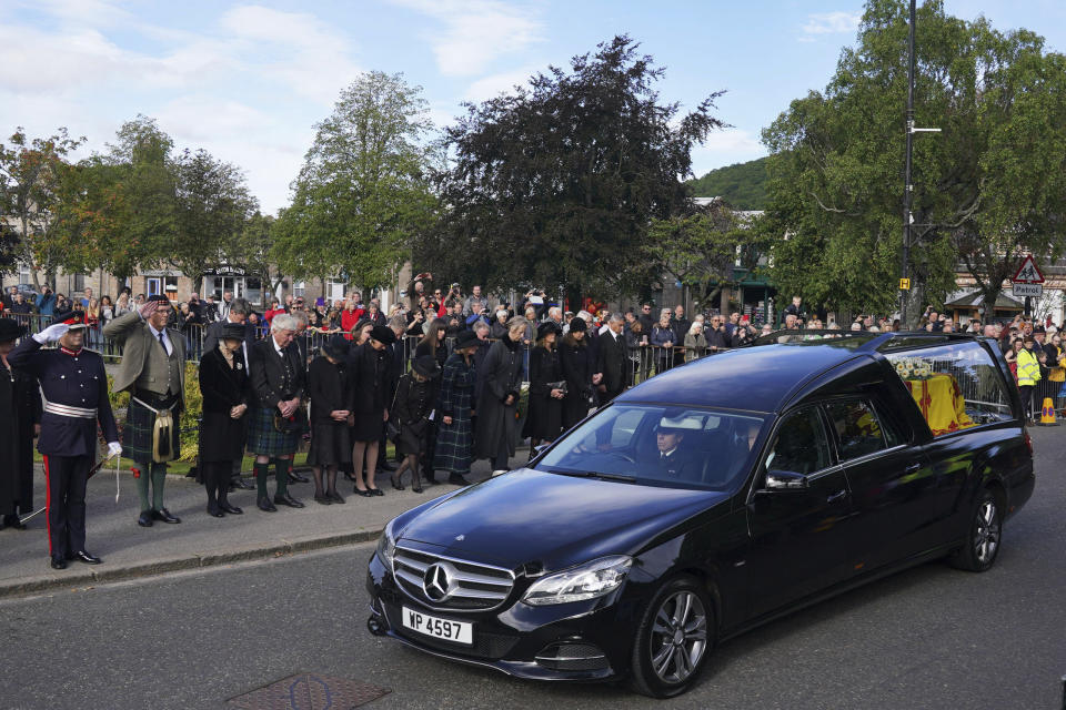 Ciudadanos en Ballater, Escocia, al paso del auto fúnebre de la reina Isabel II en su recorrido desde Balmoral a Edimburgo, en Escocia, el sábado 11 de septiembre de 2022. (Andrew Milligan/PA via AP)