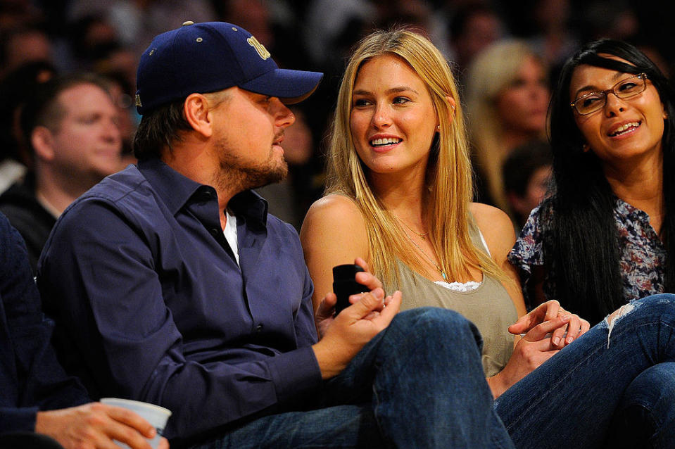 Leo and an ex-girlfriend sitting court side at a sporting event
