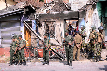 Sri Lanka's Special Task Force and Police officers stand guard near a burnt house after a clash between two communities in Digana, central district of Kandy, Sri Lanka March 6, 2018. REUTERS/Stringer
