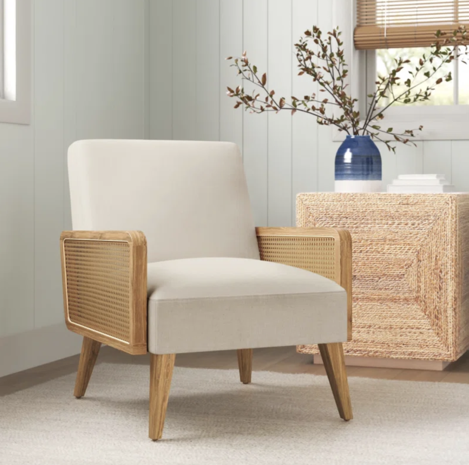 Esme 24.8'' Wide Armchair  in white and rattan arms inside home (Photo via Wayfair)