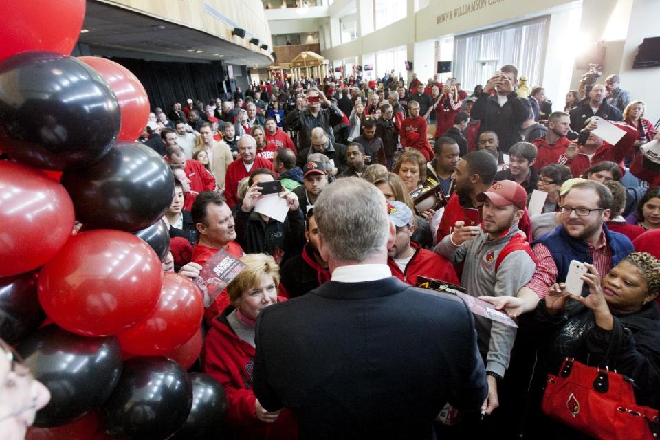 Bobby Petrino signs autographs for fans after being announced as the new University of Louisville football coach at Papa John's Cardinal Stadium, Thursday, Jan. 9, 2014, in Louisville, Ky. (AP Photo/Daily News, Alex Slitz)