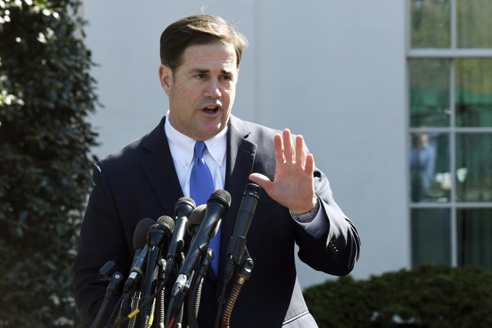 FILE - In this April 3, 2019, file photo, Arizona Gov. Doug Ducey talks to reporters outside the West Wing of the White House in Washington. Ducey is yanking a grant of up to $1 million from Nike amid a report that the athletic company pulled a flag-themed shoe from the market. (AP Photo/Susan Walsh, File)