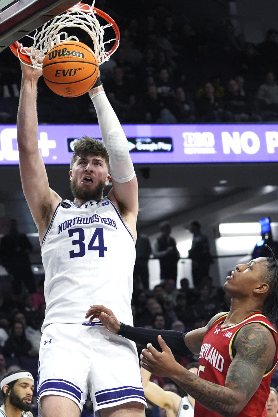 Northwestern center Matthew Nicholson, left, dunks next to Maryland guard DeShawn Harris-Smith during the second half of an NCAA college basketball game in Evanston, Ill., Wednesday, Jan. 17, 2024. (AP Photo/Nam Y. Huh)