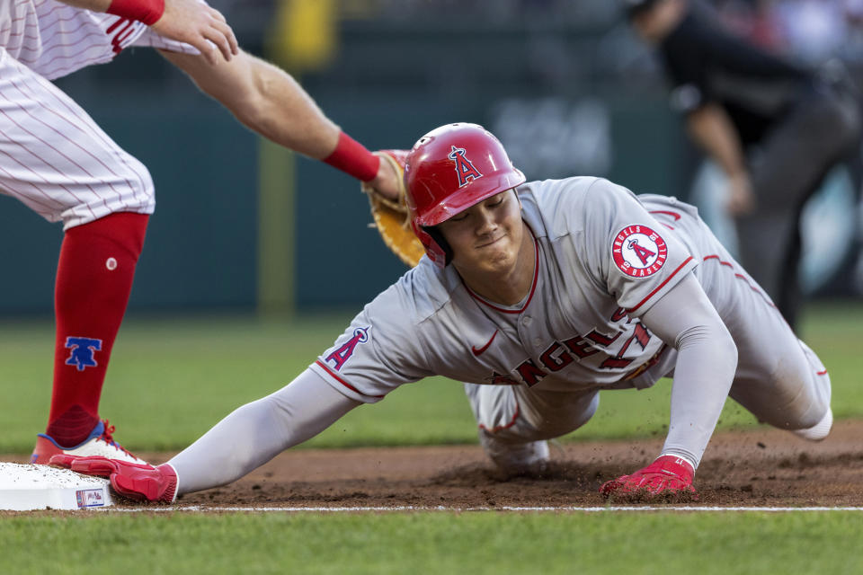 Los Angeles Angels' Shohei Ohtani is safe on a pickoff attempt before Philadelphia Phillies first baseman Rhys Hoskins (17) can make the tag during the first inning of a baseball game Saturday, June 4, 2022, in Philadelphia. (AP Photo/Laurence Kesterson)