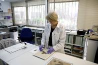 A conservator looks at a fragment from the Dead Sea Scrolls that underwent genetic sampling to shed light on the 2,000-year-old biblical trove, at the Israel Antiquities Authority laboratory in Jerusalem