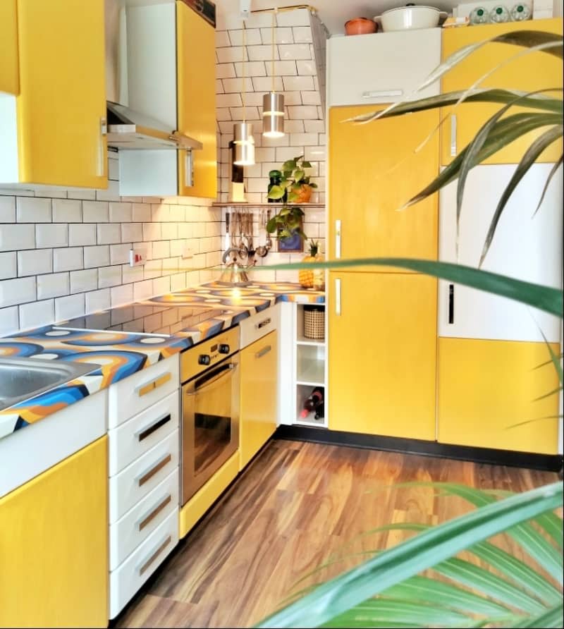 Kitchen with yellow and cabinet doors and tile backsplash.