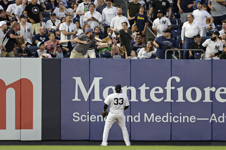 New York Yankees center fielder Franchy Cordero (33) watches as fans attempt to catch a home run by Minnesota Twins' Edouard Julien during the first inning of a baseball game Thursday, April 13, 2023, in New York. (AP Photo/Adam Hunger)