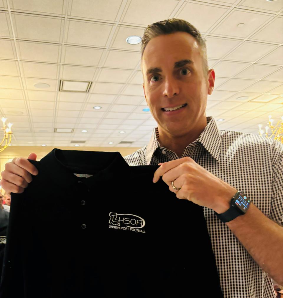 Former Shreveport resident Max Causey, who now officiates in the NFL, holds a shirt presented by the Shreveport Football Officials Association's Trey Giglio.