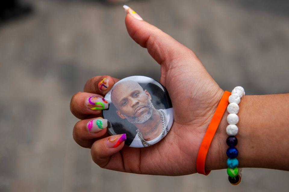 A woman holds a picture of late rapper DMX at his "Celebration of Life Memorial" at the Barclays Center on April 24, 2021, in the Brooklyn borough of New York.