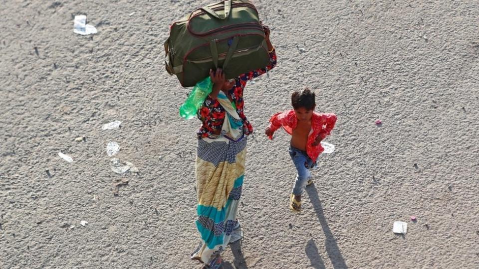 Una mujer india y su hijo viajan a su aldea natal en medio de la pandemia.