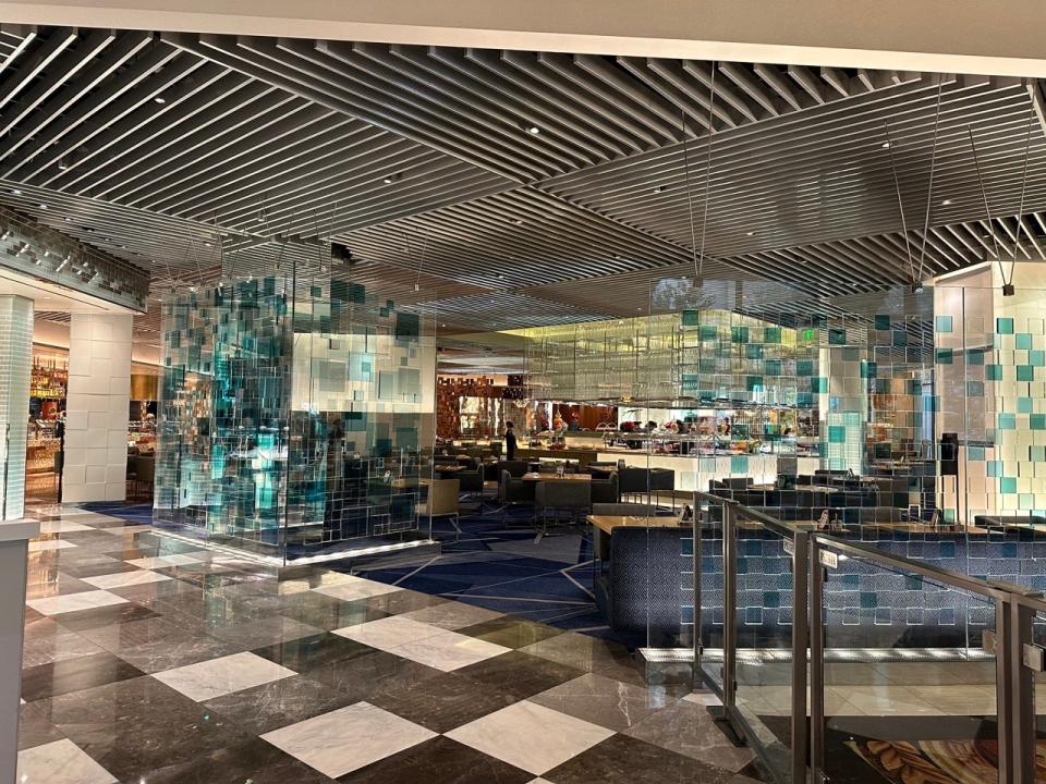 Mirrored exterior of the Bacchanal Buffet in Vegas with a view of tables and chairs inside