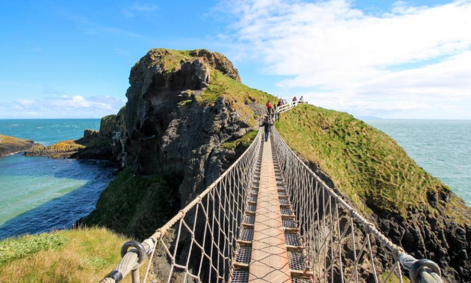 Standing on Carrick-a-Rede Rope Bridge, a famous rope bridge near Ballintoy in County Antrim, Northern Ireland, UK