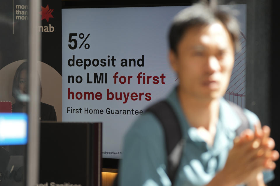 A man walks out of a National Australia Bank branch in Sydney, Tuesday, March 7, 2023. Australia’s central bank increased its benchmark interest rate by another quarter-point to 3.6% Tuesday as it continues trying to tame inflation. (AP Photo/Rick Rycroft)