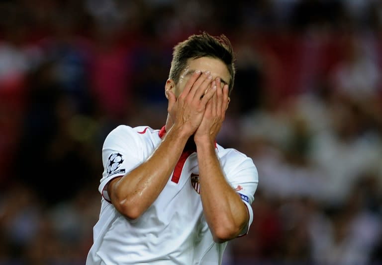 Sevilla's forward Luciano Vietto covers his face after missing a goal on September 27, 2016