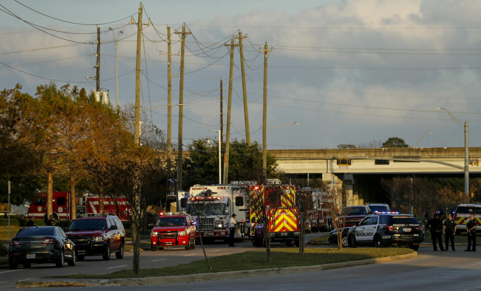 In this Sunday, Dec. 15, 2019 photo, officials respond to the scene of a mercury spill on the intersection of Westview Drive and West Sam Houston Parkway North in Houston. A person has been taken into custody for questioning after dozens of people were decontaminated as a precaution due to trace amounts of mercury spilled at three locations in Houston, the FBI said Monday. (Godofredo A. Vásquez/Houston Chronicle via AP)