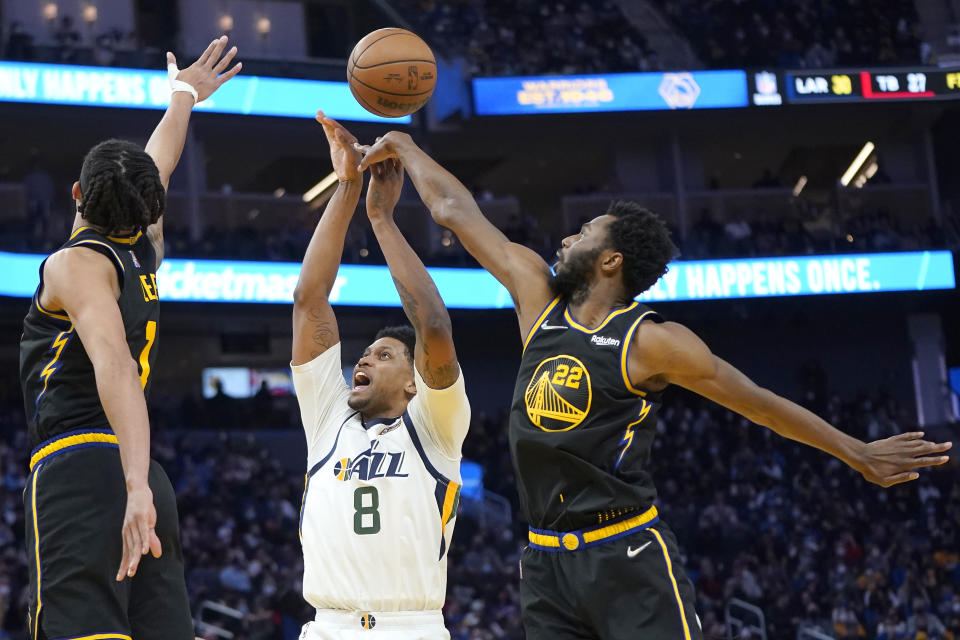 Golden State Warriors forward Andrew Wiggins (22) blocks a shot by Utah Jazz forward Rudy Gay (8) during the second half of an NBA basketball game in San Francisco, Sunday, Jan. 23, 2022. (AP Photo/Jeff Chiu)