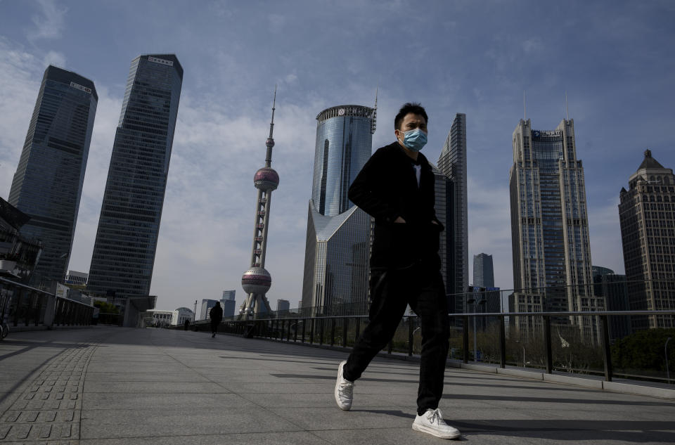 A man wearing a protective face mask walks on an overpass in Lujiazui financial district in Shanghai on February 10, 2020. - The death toll from the novel coronavirus surged past 900 in mainland China on February 10, overtaking global fatalities in the 2002-03 SARS epidemic, even as the World Health Organization said the outbreak appeared to be stabilising. (Photo by NOEL CELIS / AFP) (Photo by NOEL CELIS/AFP via Getty Images)