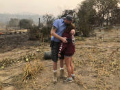 Kevin Conant and his wife, Nikki, hug after looking at the debris of their burnt home and business "Conants Wine Barrel Creations," after the Glass/Shady fire completely engulfed it, Wednesday, Sept. 30, 2020, in Santa Rosa, Calif. The Conants escaped with their lives, which we are grateful for, but they barely made it out with the clothes on their backs in the wake of the fire. The Glass and Zogg fires are among nearly 30 wildfires burning in California. (AP Photo/Haven Daley)