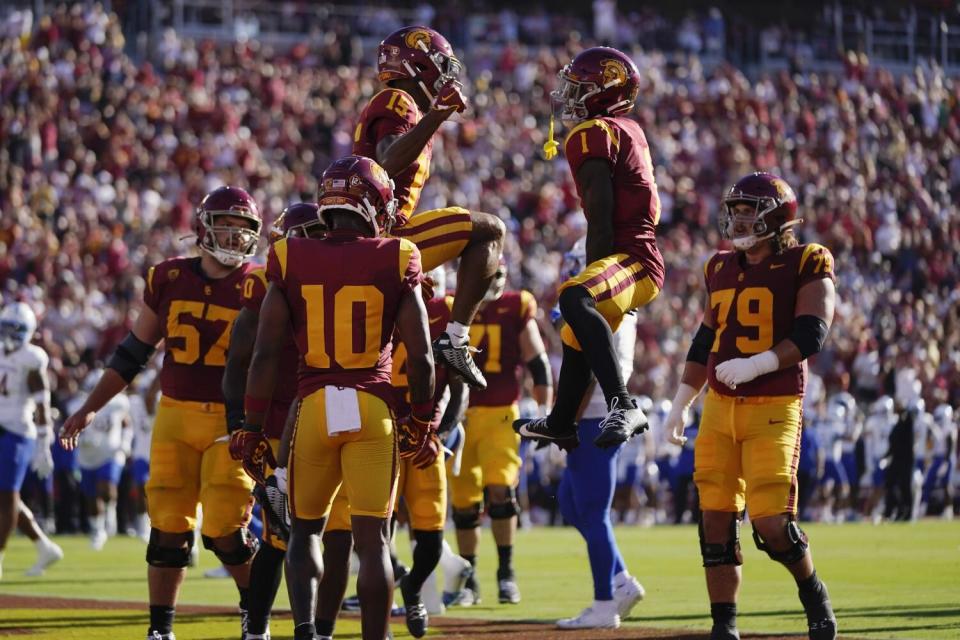 USC players hoist Dorian Singer aloft after he scores a touchdown.