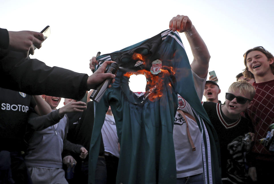 Hinchas prenden fuego a una camiseta de Liverpool en las afueras del estadio Elland Road de Leeds, el lunes 19 de abril de 2021. (Zac Goodwin/PA via AP)