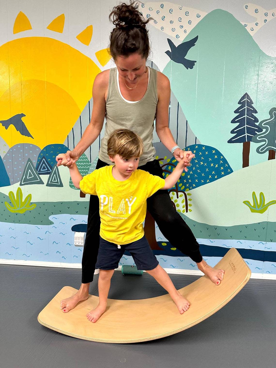 Children’s yoga teacher Kate Murphy leads a student on a Wobbel balance board during a class at Nanda Yoga studio.