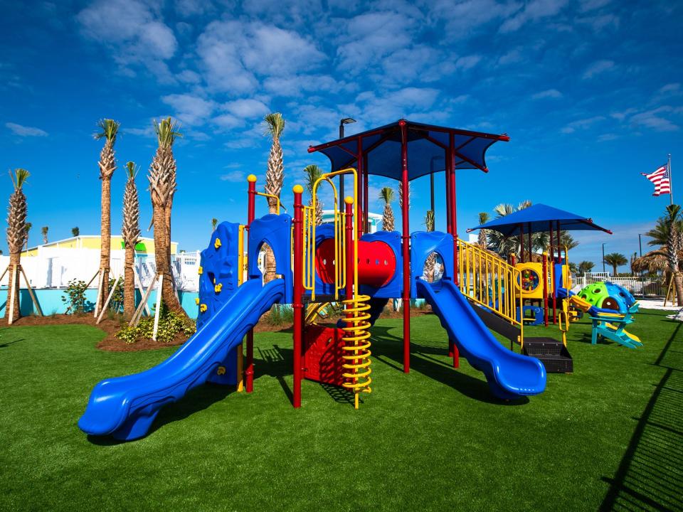 An empty children's' playground with a colorful play gym.