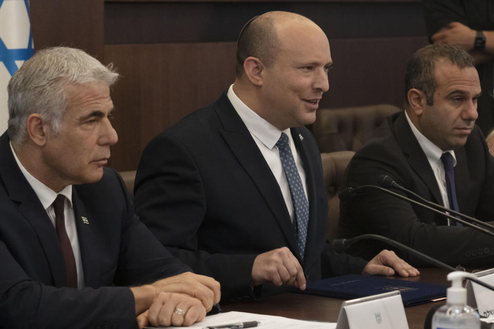 Israeli Prime Minister Naftali Bennett, center, makes a statement at the start of the weekly cabinet meeting seated next to Foreign Minister Yair Lapid, left, in Jerusalem, Sunday, May 8, 2022. (AP Photo/Maya Alleruzzo, Pool)