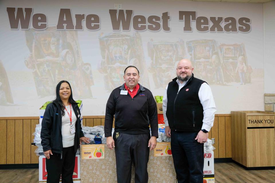 Wendy Lara and Major Tex Ellis of the Salvation Army of Amarillo stand with United Supermarkets store director Fernando Noriega as they receive 1,000 pairs of socks Tuesday from the Pears for Pairs program in Amarillo.