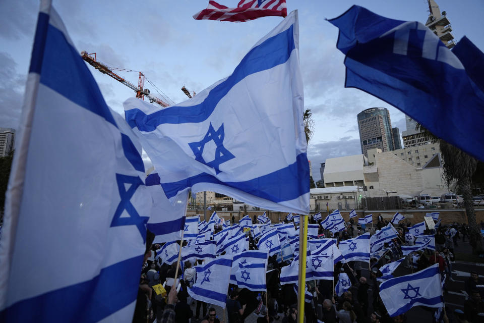 National flags flutter as right-wing Israelis rally in support of Prime Minister Benjamin Netanyahu's government plans to overhaul the judicial system, in Tel Aviv, Israel, Thursday, March 30, 2023. (AP Photo/Ariel Schalit)