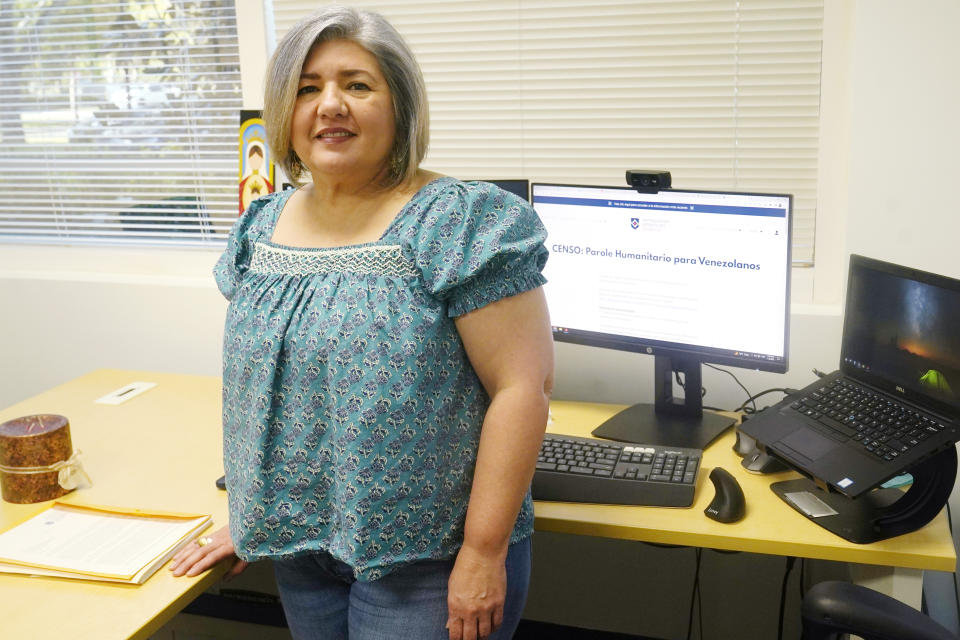 Maria Antonieta Diaz stands at her desk, Thursday, Jan. 5, 2023, in Miramar, Fla. Diaz has sponsored several Venezuelans under a parole program started in October. The Biden administration announced an expansion of that program to Cubans, Nicaraguans and Haitians seeking to enter the U.S. (AP Photo/Marta Lavandier)