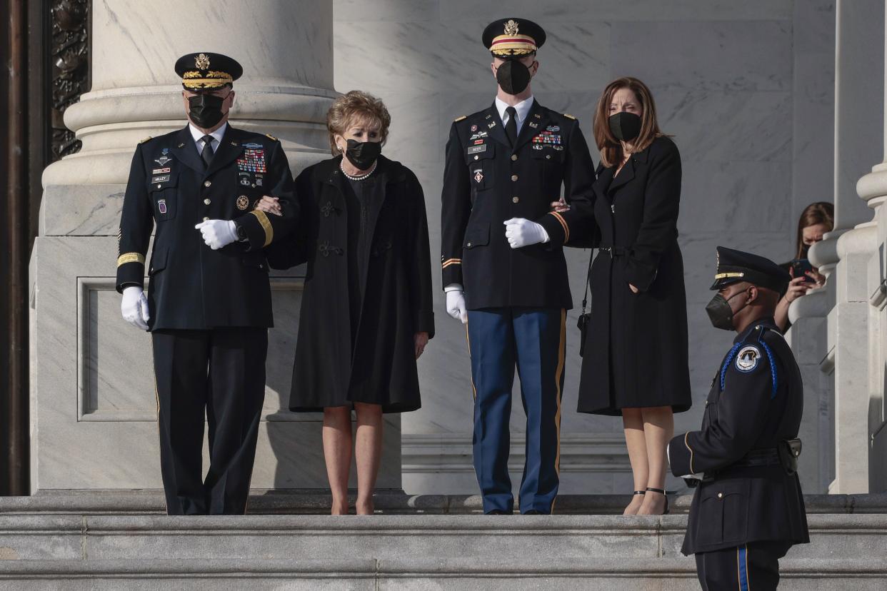 Elizabeth Dole, second from left, their daughter Robin, watch as a joint services military bearer team moves the casket of Sen. Bob Dole, R-Kan. during arrival at the U.S. Capitol, where he will lie in state in the Rotunda, Thursday Dec. 9, 2021, on Capitol Hill in Washington, D.C. Chairman of the Joint Chiefs of Staff Gen. Mark Milley is at left.