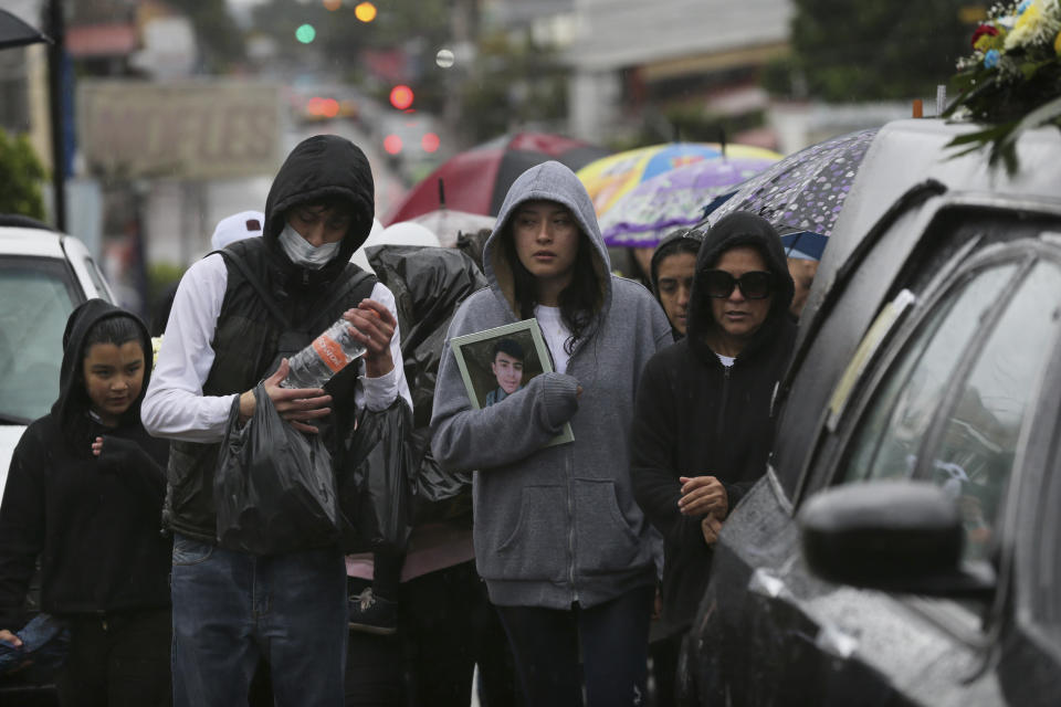 Familiares y amigos participan en una procesión funeraria para una víctima de un tiroteo en un negocio de videojuegos en Uruapan, México, el miércoles 5 de febrero de 2020. (AP Foto/Marco Ugarte)